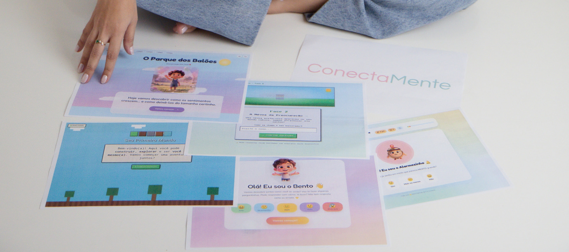 Foto dos materiais terapêuticos do ConectaMente: telas de atividades digitais, cards com personagens infantis e recursos lúdicos sobre superfície clara